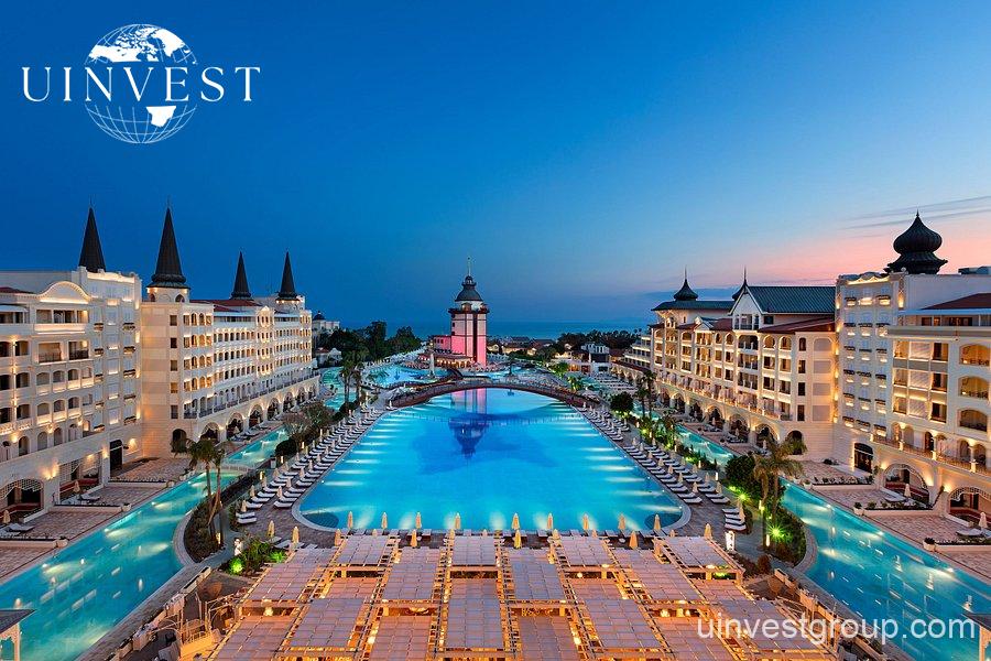 Luxury Turkish hotel exterior with lush gardens, perfect getaway for male travelers seeking comfort and nature.